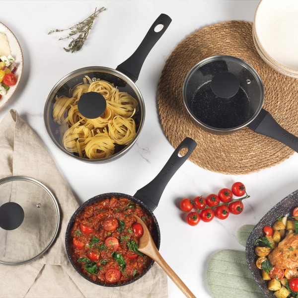 Set of black speckled non-stick cookware with assorted meals, shown from above