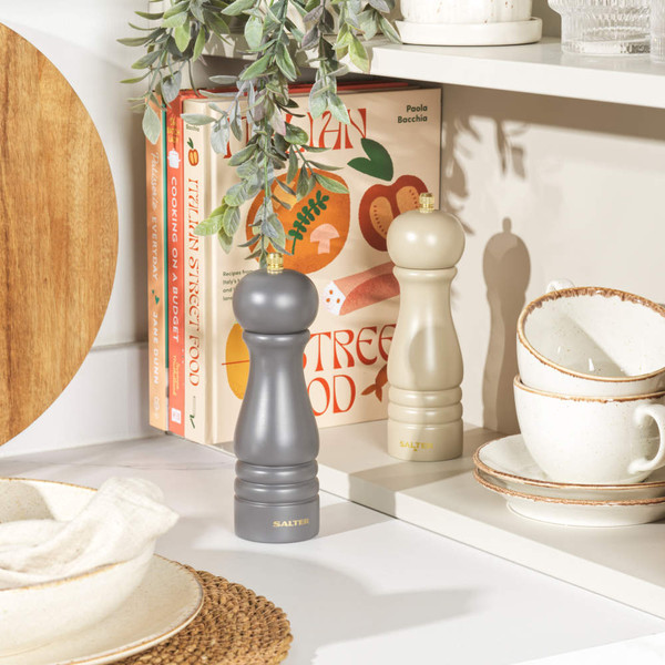 Set of two Salter salt and pepper mills, one matte black and one cream, on kitchen shelf