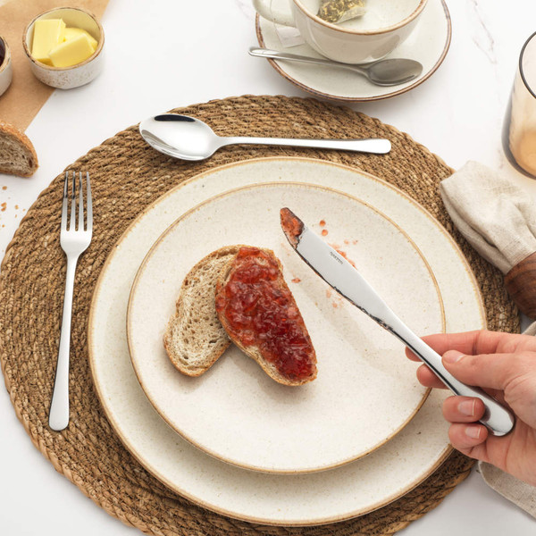 Set of four silver stainless steel cutlery pieces: fork, knife, dessert spoon, teaspoon.