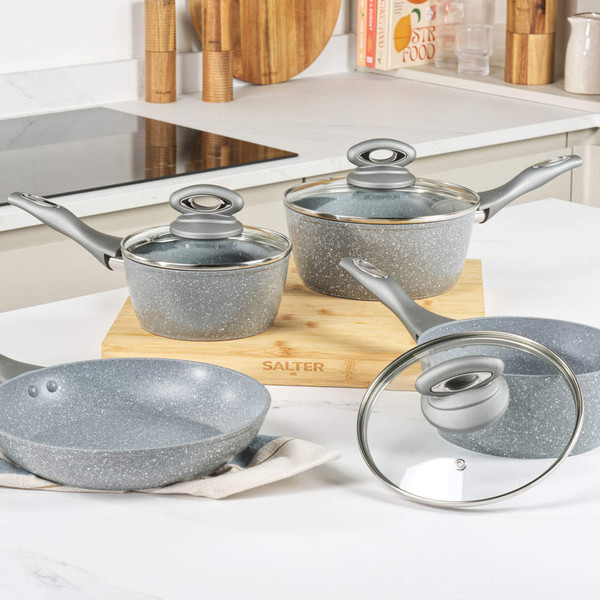 Set of grey speckled non-stick saucepans and frying pan with glass lids on kitchen worktop