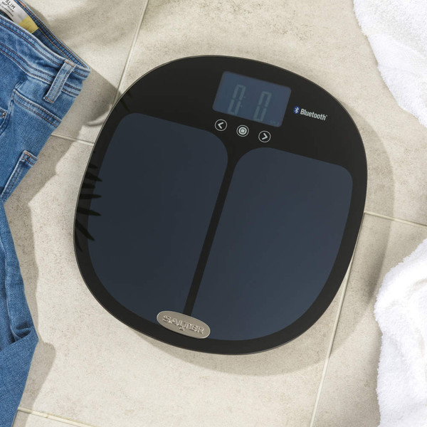 Black Salter digital bathroom scale with Bluetooth, shown on tiled floor.