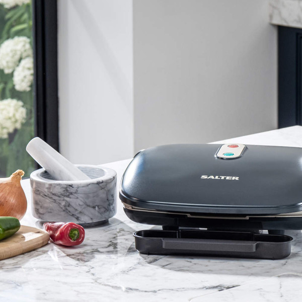 Electric grill with open lid showing vegetable and halloumi skewers on plates