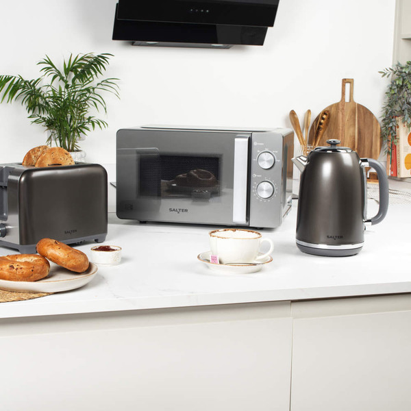Gunmetal toaster with removable crumb tray extended for cleaning, shown on kitchen worktop.