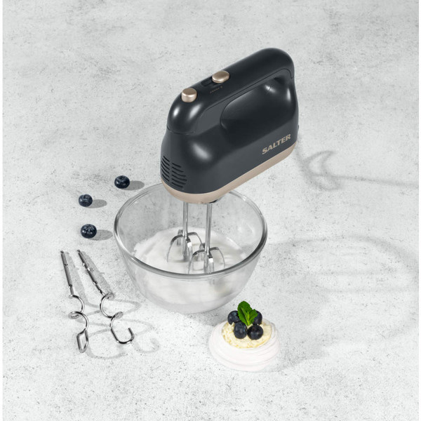 Salter black hand mixer whisking cream in glass bowl, extra beaters shown, countertop view