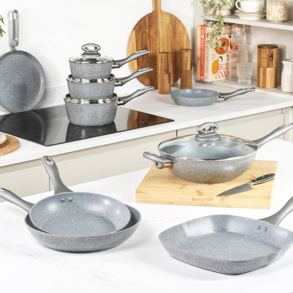 Grey non-stick frying pan with glass lid and two handles, shown at an angle