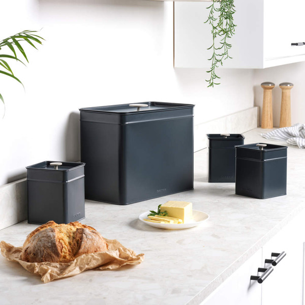 Dark grey kitchen storage set with bread, butter dish and three canisters on counter