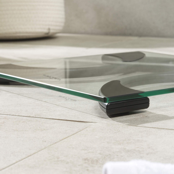 Glass digital bathroom scale with black accents and large display, showing 0.0 kg