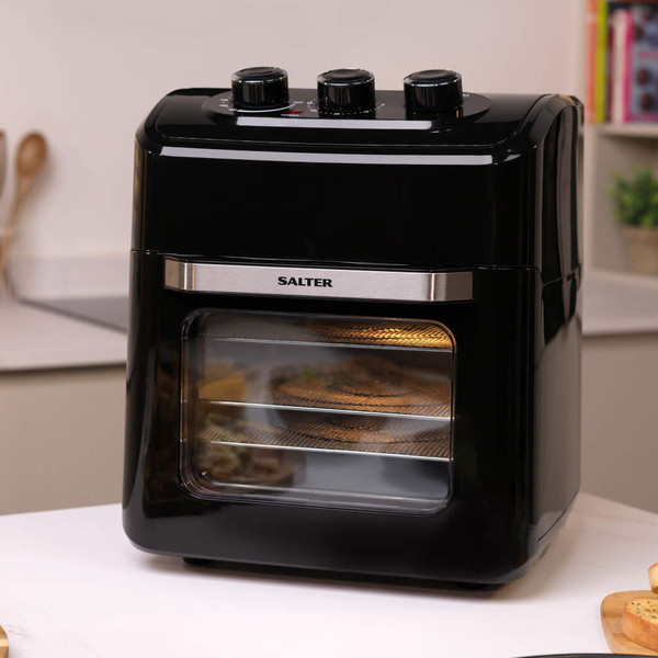 Black Salter air fryer oven with three control dials, shown on kitchen counter