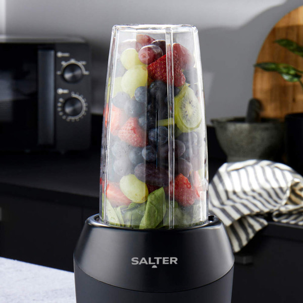 Black Salter blender with clear cup filled with assorted fresh fruit, shown on kitchen counter