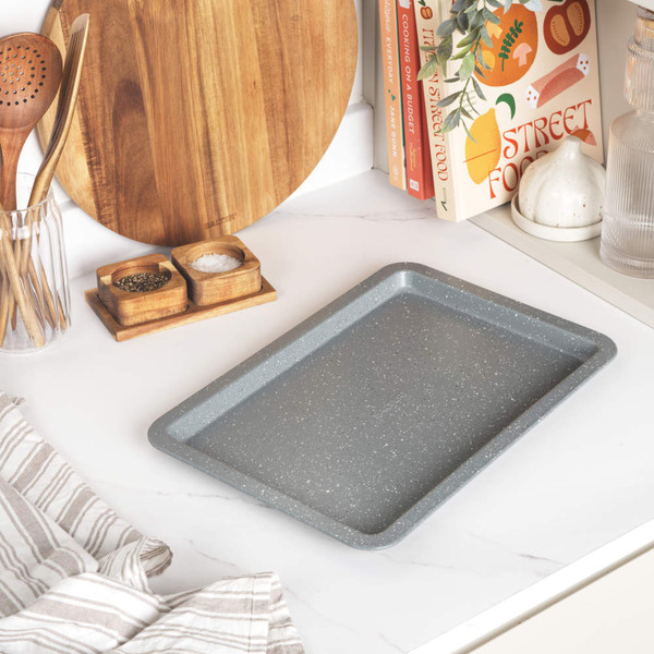 Grey non-stick baking tray with four cookies, promotion for Salter Marblestone 37cm tray