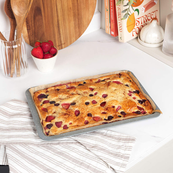 Grey speckled rectangular oven tray with raised edges, shown at an angle