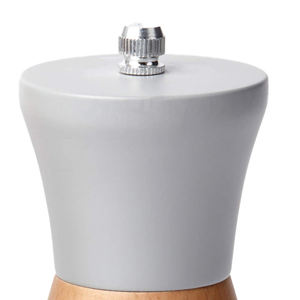 Close-up of grey and wood manual pepper mill top, showing adjustment knob.