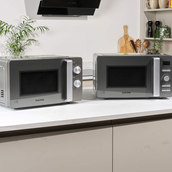 Pair of Salter grey microwaves on kitchen counter, showing manual and digital controls.