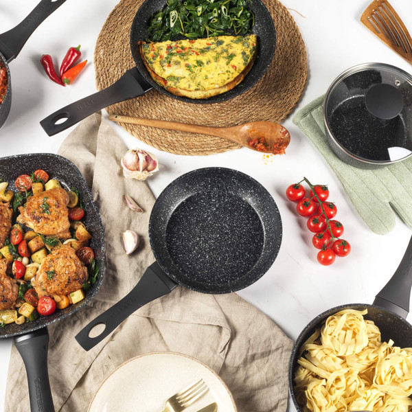 Set of black speckled non-stick saucepans and frying pans in a modern kitchen