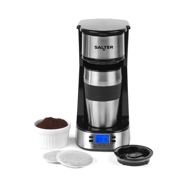 Single-serve silver coffee maker with travel mug, coffee grounds, and coffee pods shown.