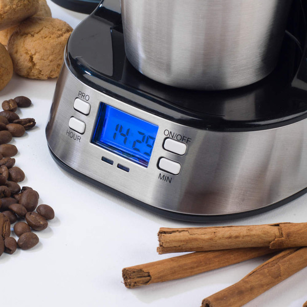 Stainless steel digital coffee grinder on white surface with cinnamon sticks and cookies.