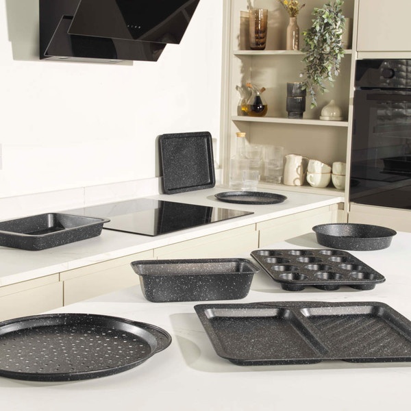 Set of black speckled non-stick baking trays and tins displayed in a kitchen