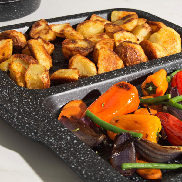 Non-stick oven tray with roast potatoes and mixed roasted vegetables