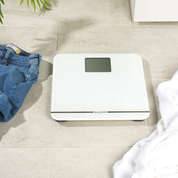 White Salter digital bathroom scale on tiled floor, shown from above
