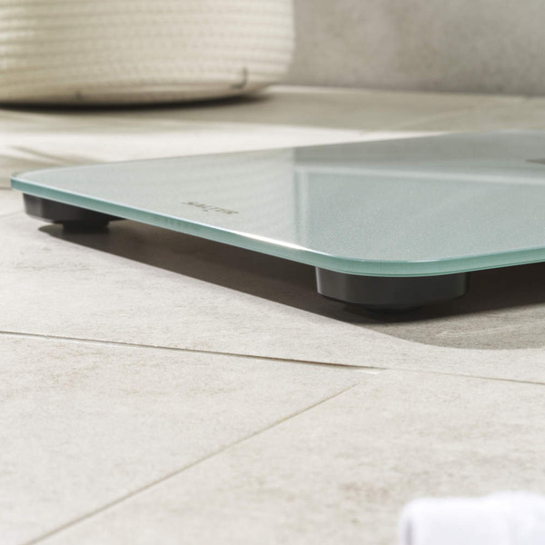 Silver digital bathroom scale with large blue-lit display, front view.