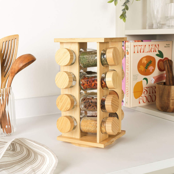 Rotating bamboo spice rack with full spice jars, shown on a kitchen counter.