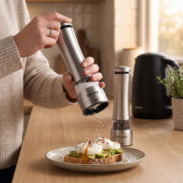 Pair of stainless steel electric salt and pepper grinders on kitchen worktop
