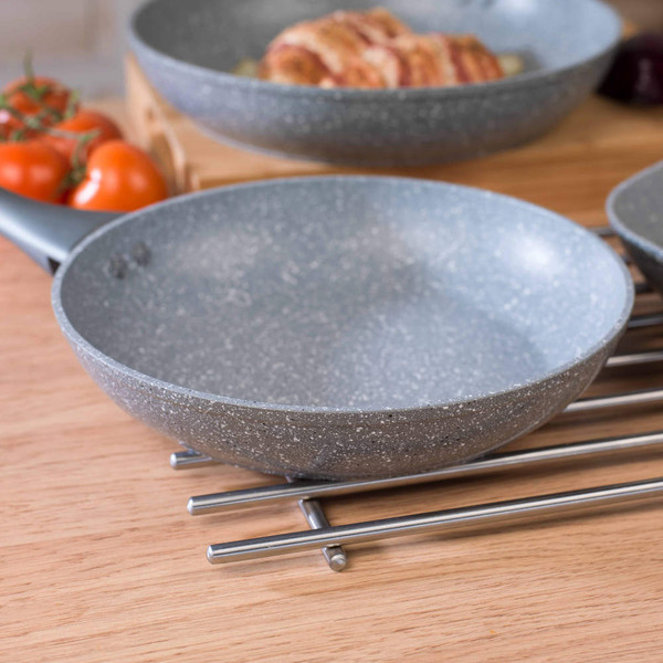 Grey frying pan handle with fresh red tomatoes on wooden surface