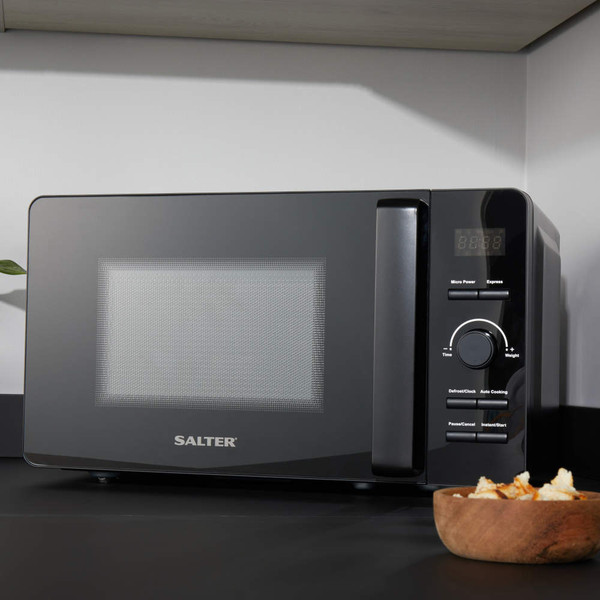 Black Salter microwave on kitchen worktop with control panel, plant and snack bowl beside