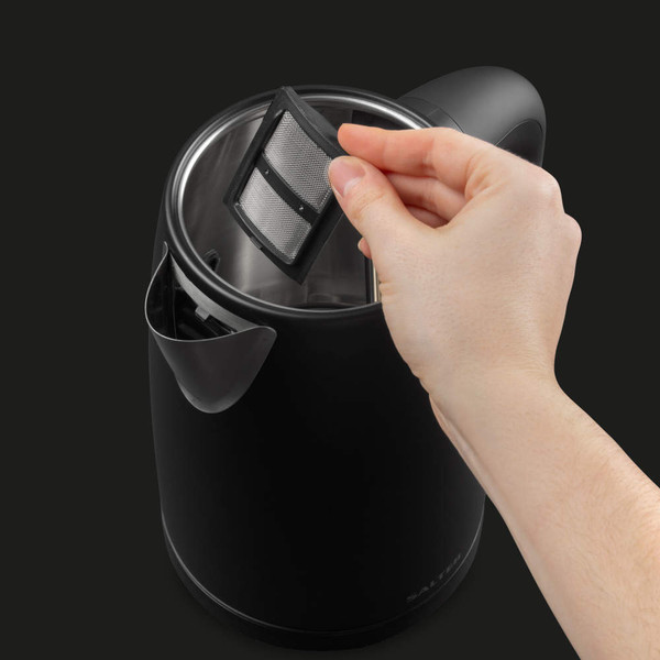 Hand removing limescale filter from black electric kettle