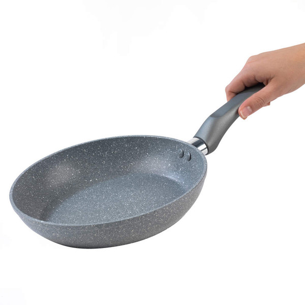 Grey non-stick frying pan with ergonomic handle, held in right hand