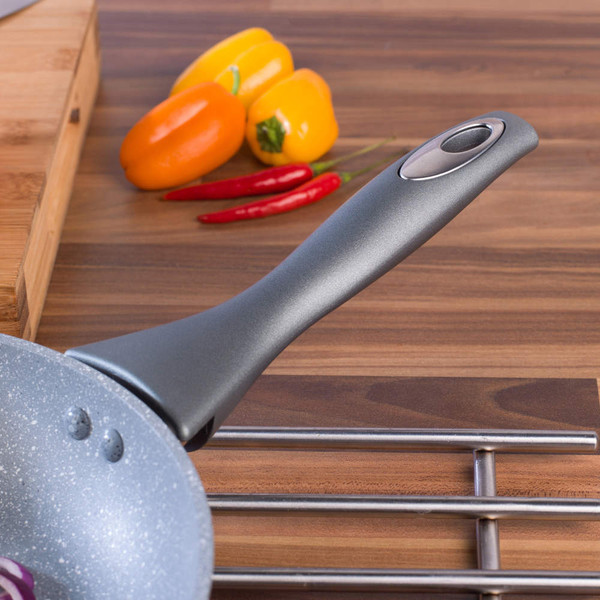 Grey non-stick frying pan handle, close-up, on kitchen worktop