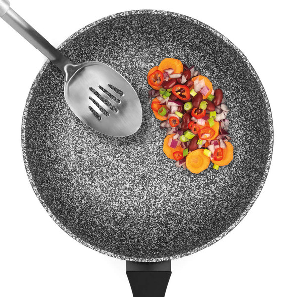 Granite-effect non-stick wok with metal slotted spoon and sliced vegetables.