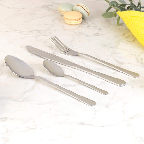 Stainless steel cutlery set with knife, fork, dessert spoon and teaspoon on marble surface