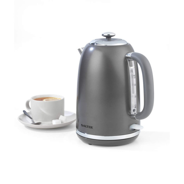 Grey electric kettle with side handle, shown next to cup of tea with lemon slice.