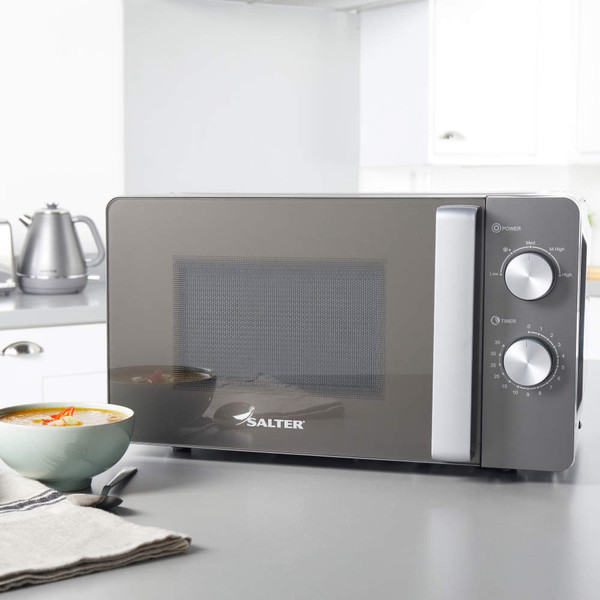 Salter black microwave on grey kitchen counter with bowl of soup