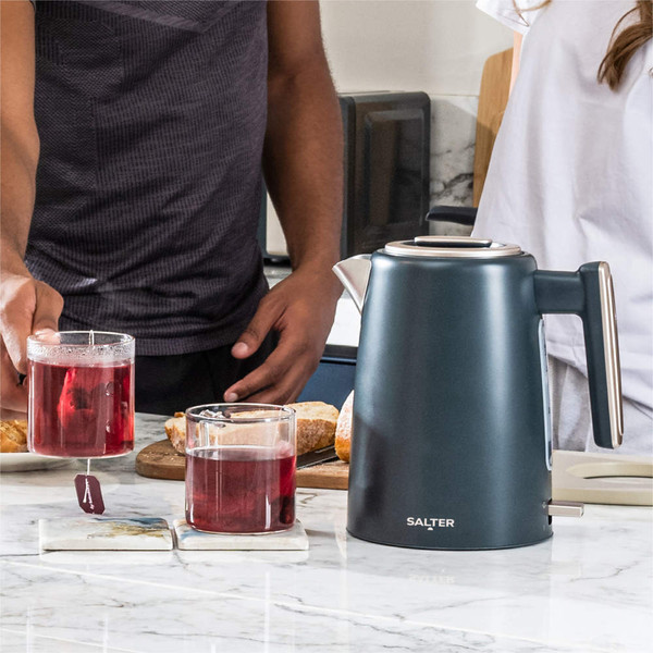 Matte grey electric kettle with chrome accents on kitchen counter next to tea and glasses