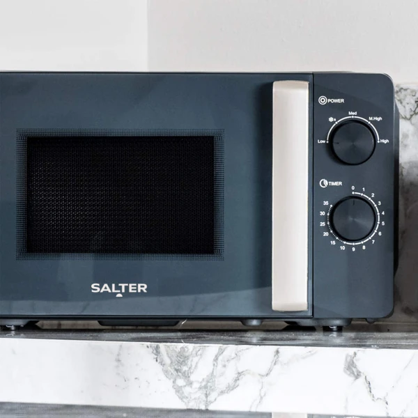 Close-up of grey microwave oven showing open door and control dials for power and timer
