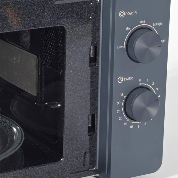 Close-up of grey microwave oven showing open door and control dials for power and timer