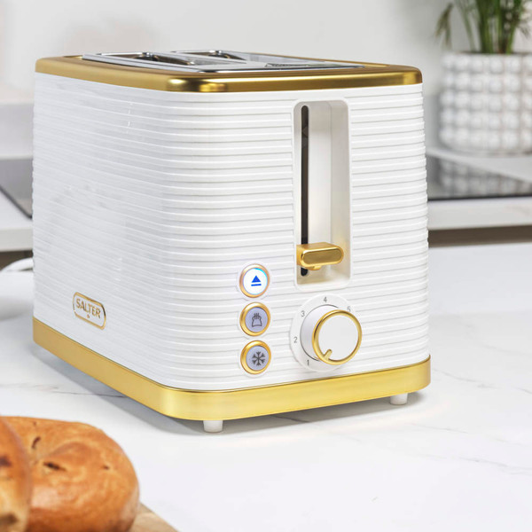 White and gold two-slice toaster with ribbed design in kitchen setting