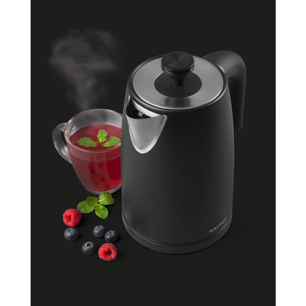 Matte black electric kettle with stainless steel lid, next to a glass cup of tea and mixed berries.