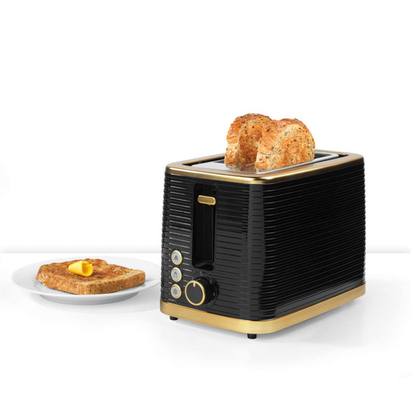 Black and gold toaster with two slices of brown bread, plus buttered toast on plate