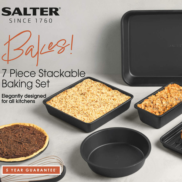 Black 7 piece stackable baking set with tray, tins and round cake tin, shown with baked goods