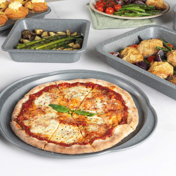 Grey non-stick oven tray with grilled aubergine, asparagus, broccoli, and tomatoes