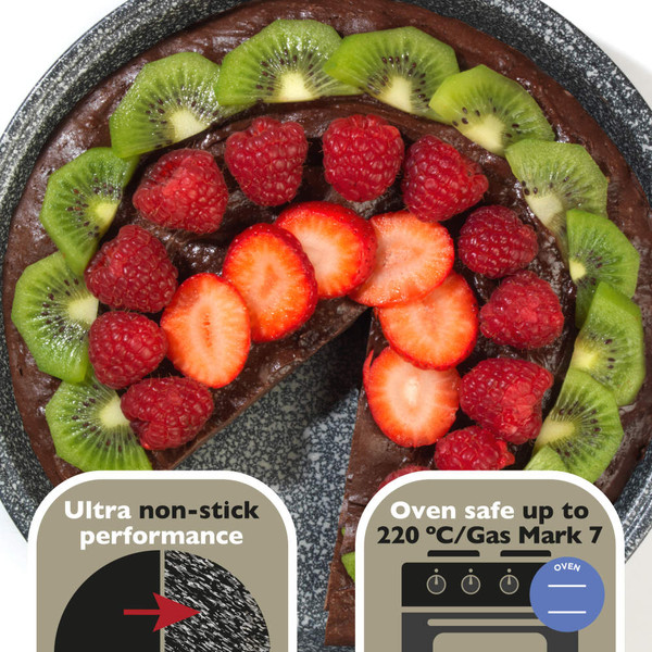 Chocolate cake with sliced kiwi, raspberry and strawberry topping on a speckled plate.