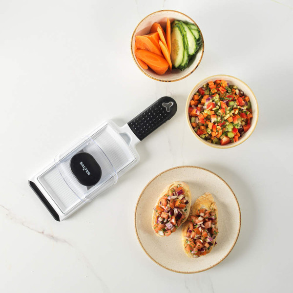 Salter hand-held mandoline slicer with black handle next to bowls of sliced vegetables and bruschetta.