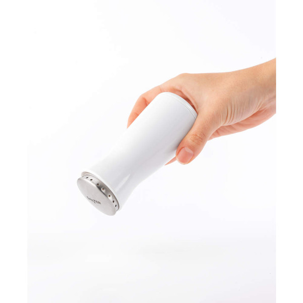 Hand holding white Salter shaker angled to pour
