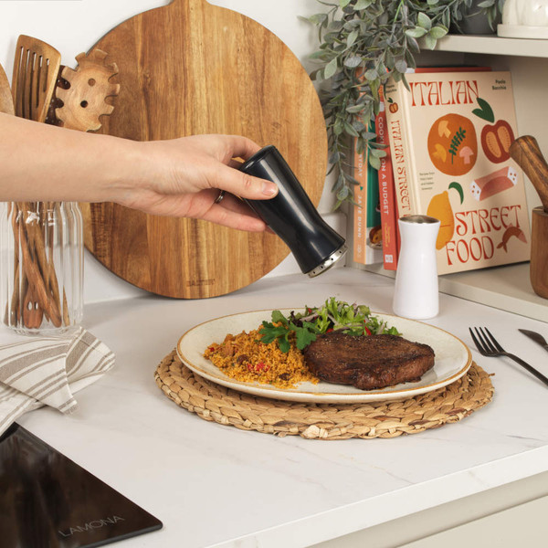 Set of two Salter grinders, one black and one white, with stainless steel tops.