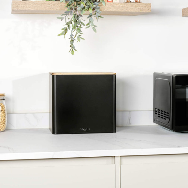 Black metal square bread bin with wooden lid on kitchen worktop