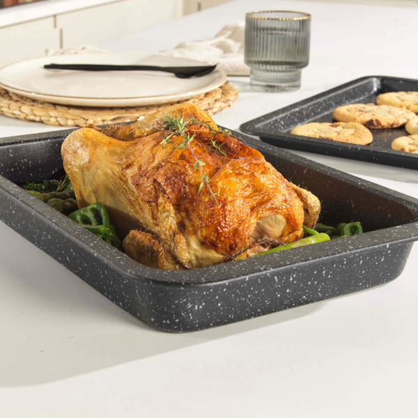 Grey speckled roasting tin with cooked chicken, shown on a kitchen worktop