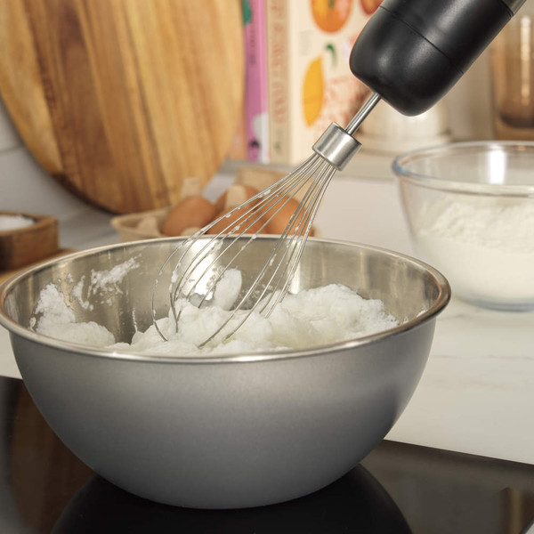 Hand blender blending strawberries and cherries in glass bowl